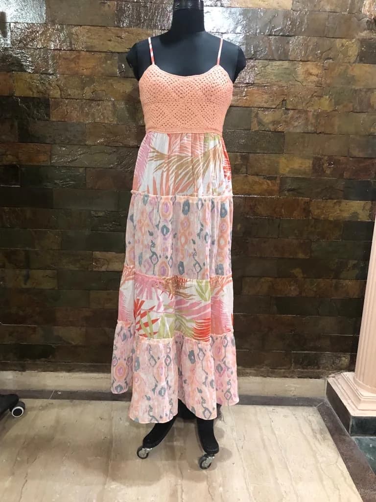Front view of a coral crochet-bodice tropical print tiered maxi dress on a dress form