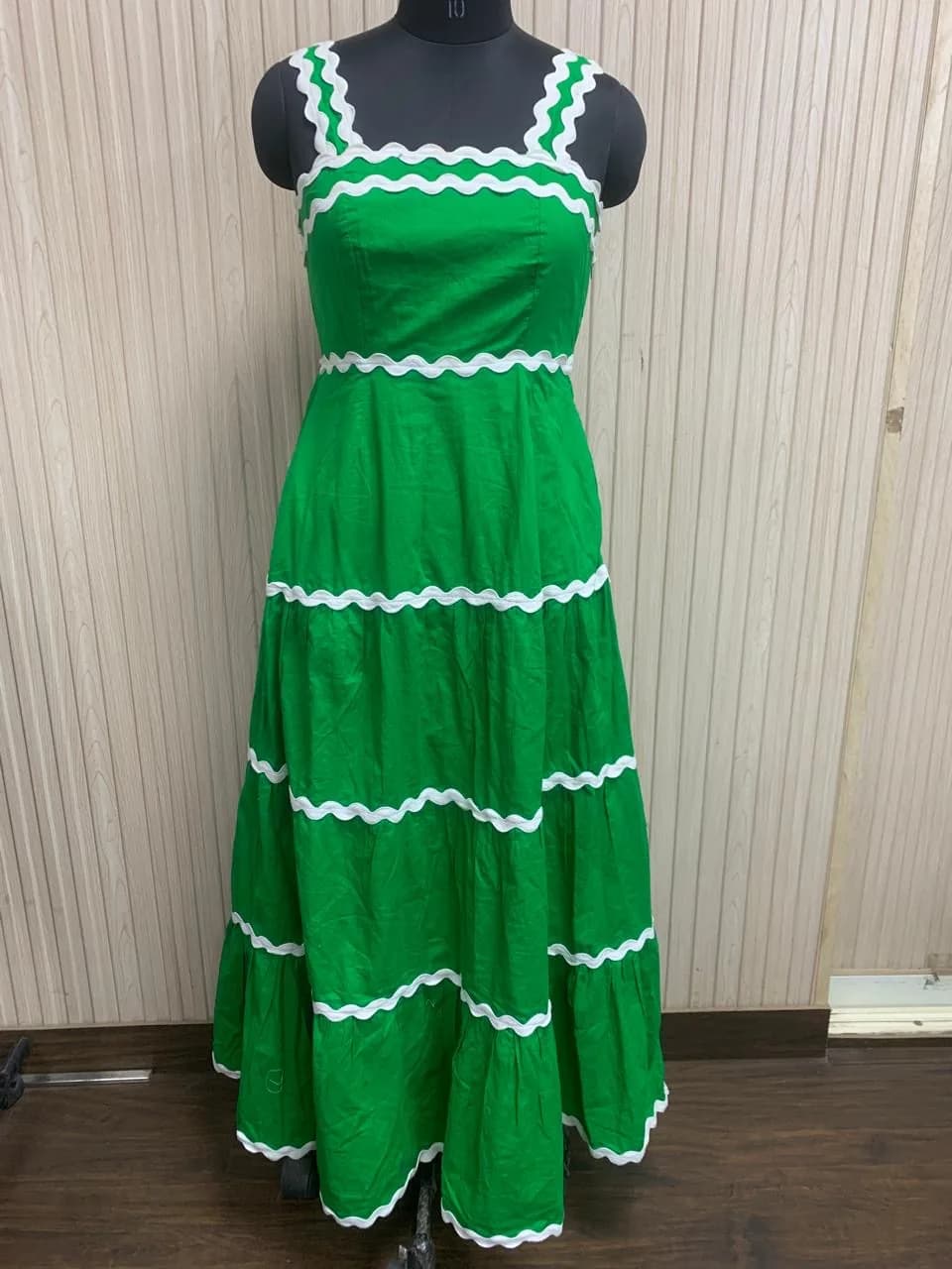 Front view of a green ric-rac trim tiered maxi dress on a dress form